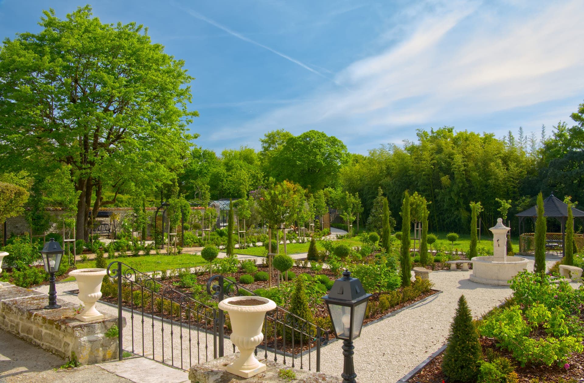 Château Lesvescault — formal French gardens with topiary, stone urns and fountain, Villefagnan