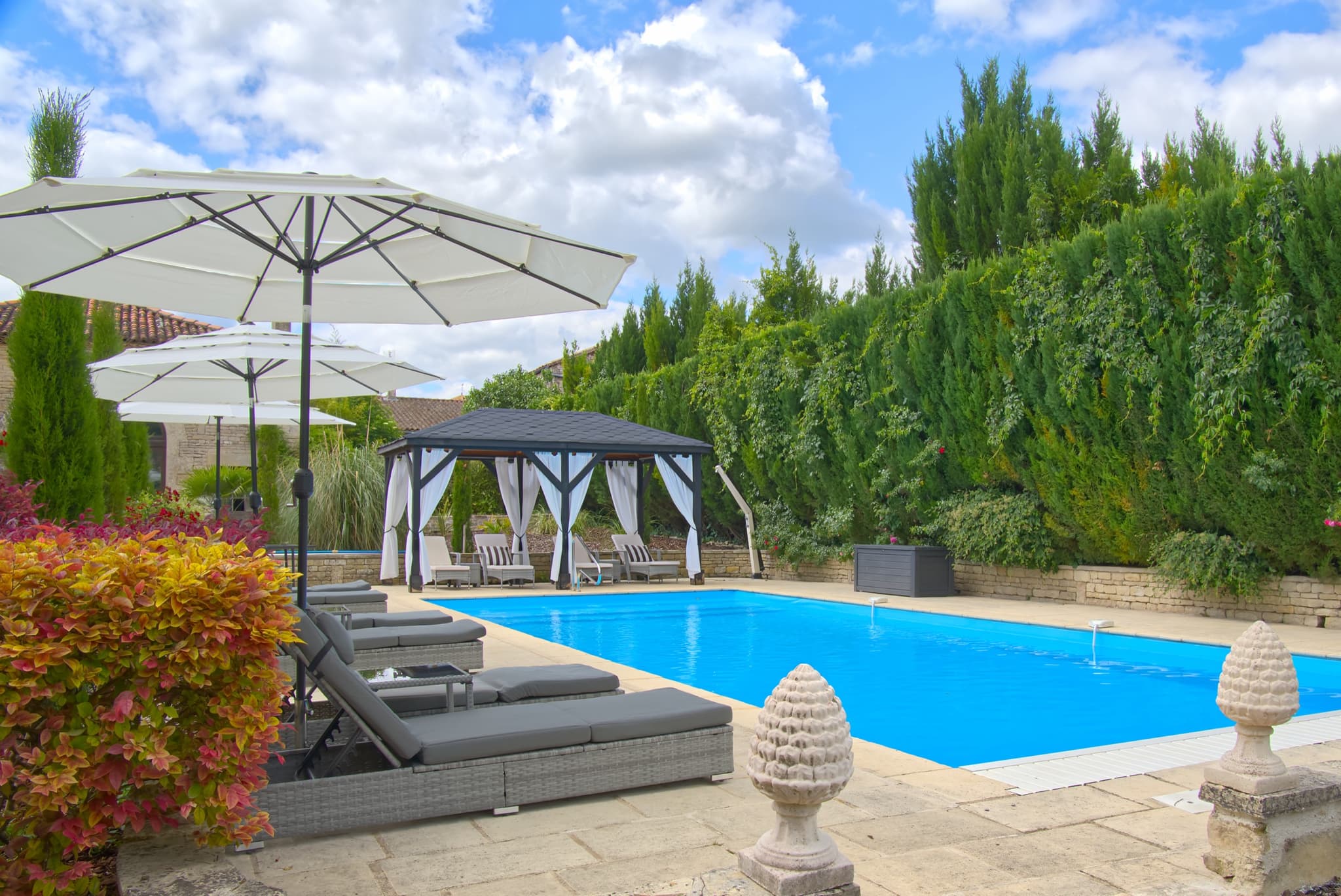 Château Lesvescault — heated saltwater pool with sunloungers, parasols and poolside cabana